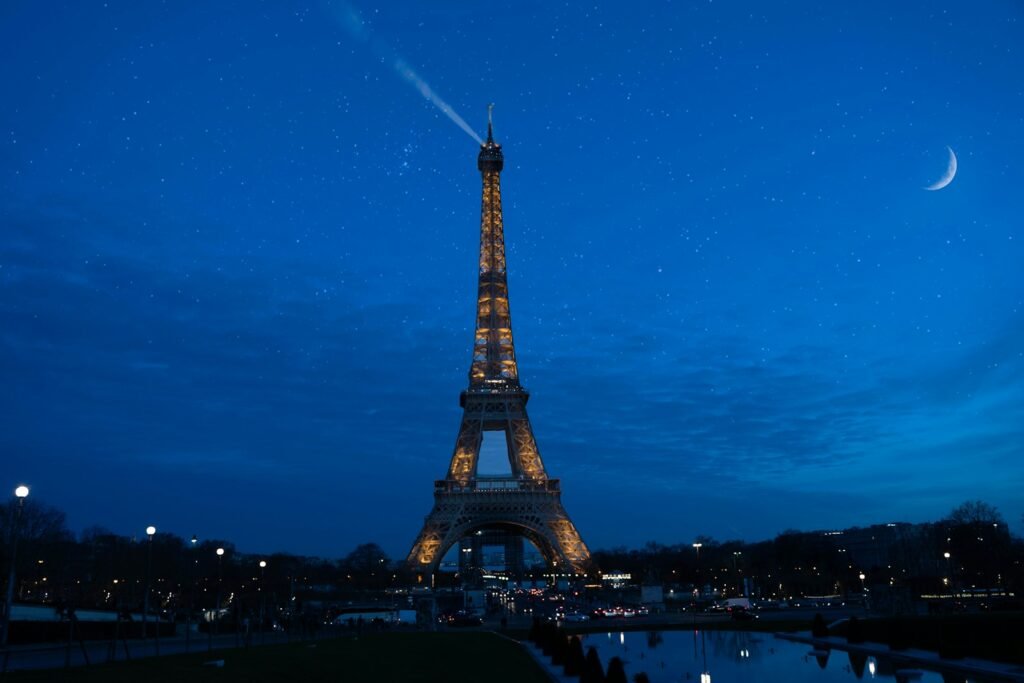 the eiffel tower is lit up at night