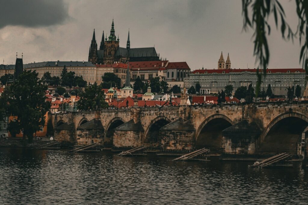 a bridge over a body of water with a castle in the background